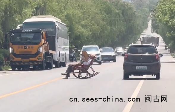 大爷躺马路中间晒太阳 车辆纷纷避让