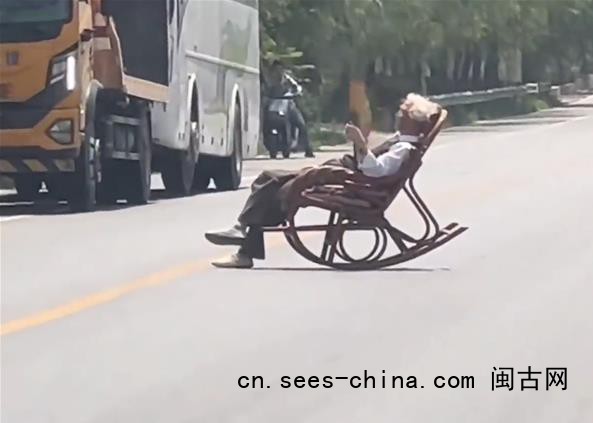 大爷躺马路中间晒太阳 车辆纷纷避让